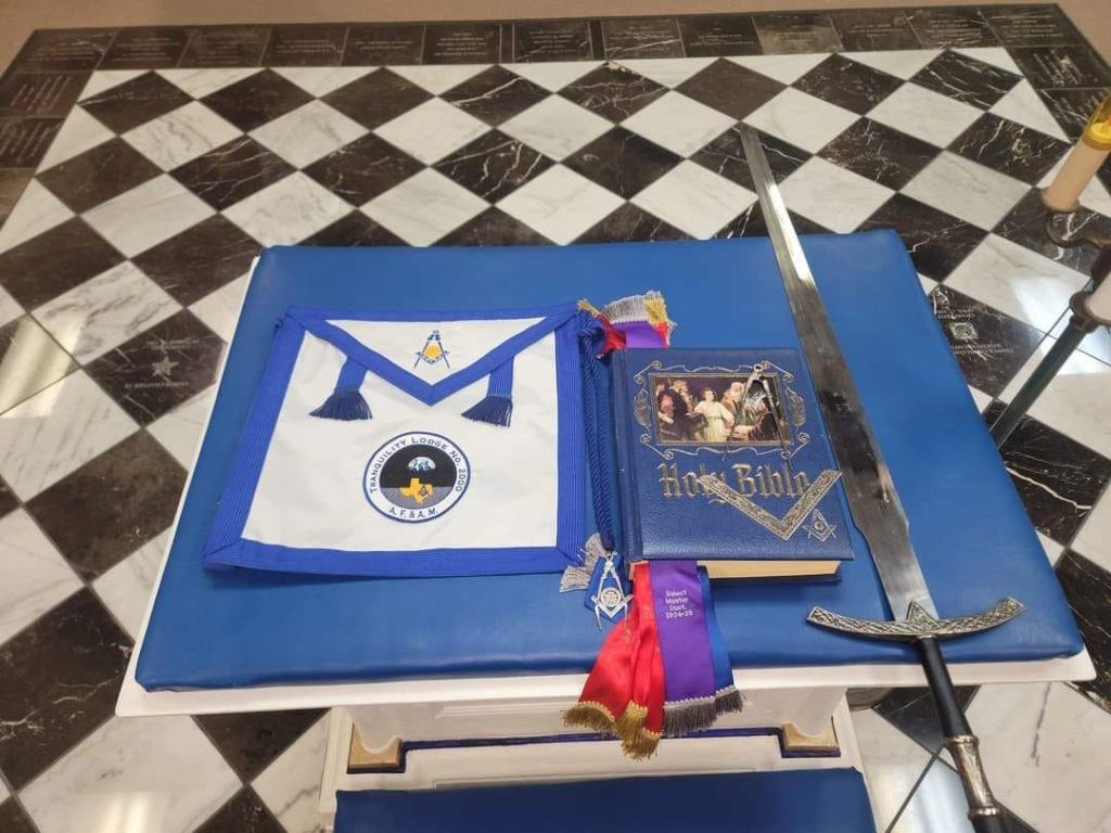 Lodge apron, Bible, and ceremonial sword displayed at the stated meeting
